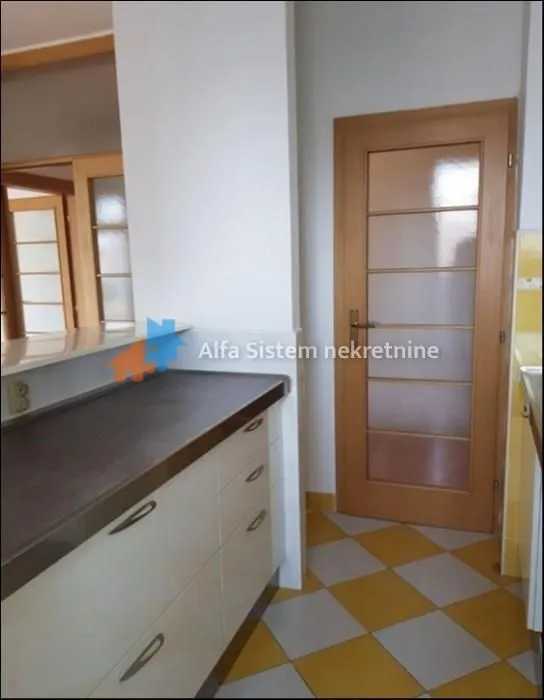 View of the kitchen unit and a wooden door in the interior.