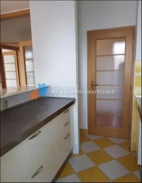 View of the kitchen unit and a wooden door in the interior. - image 3