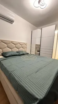 Furnished bedroom with a double bed, air conditioning unit, and a large wardrobe. - image 4