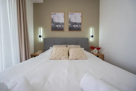 Svijetla spavaća soba sa modernim bračnim krevetom i dekorativnim lampama. - image 19