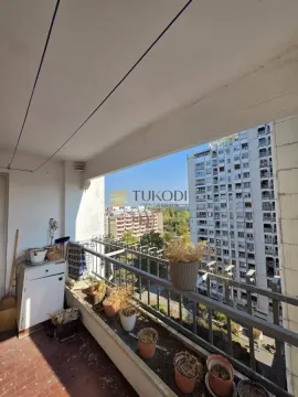 Natkriveni balkon sa saksijama i pogledom na okolne stambene zgrade. - image 17