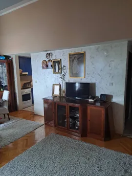 Dnevna soba sa drvenom komodom, televizorom i parketom na podu. - image 2