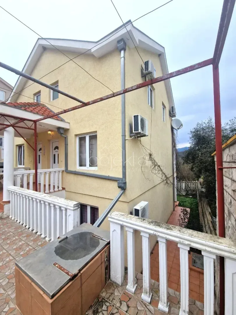 Pogled na spoljašnjost kuće sa terasom i dvorištem.