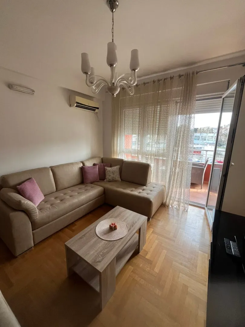 Living room with a sectional sofa, coffee table, and access to the terrace.