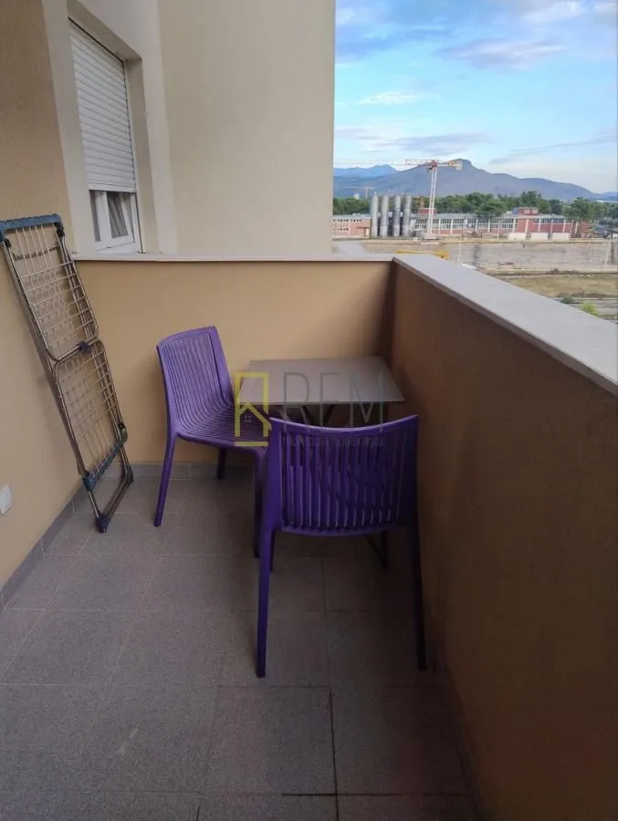 Nenameštena terasa sa stolom, stolicama i sušačem za veš.