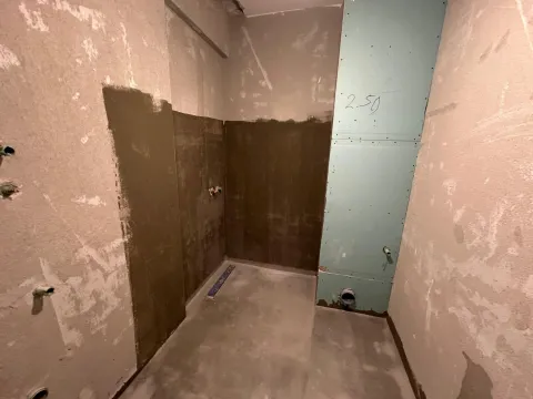View of a room under construction with prepared plumbing installations. - image 4