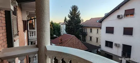 View from the balcony overlooking surrounding buildings and trees. - image 15