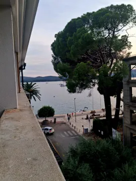 Pogled na more sa terase sa drvećem i šetalištem u okolini. - image 6