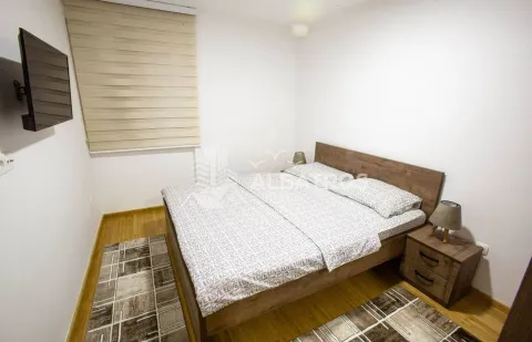Furnished bedroom with a double bed, bedside tables, and a wall-mounted TV. - image 6