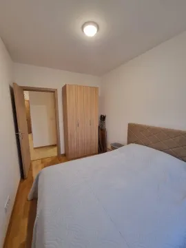 Namještena spavaća soba sa bračnim krevetom i drvenim ormarom. - image 10