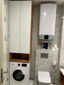 Modern bathroom with a washing machine and built-in fixtures. - image 9