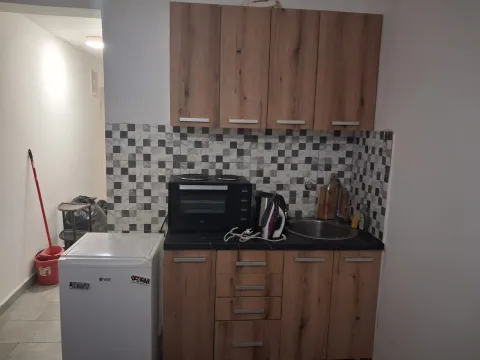Smaller kitchen with wooden cabinets and a sink. - image 7