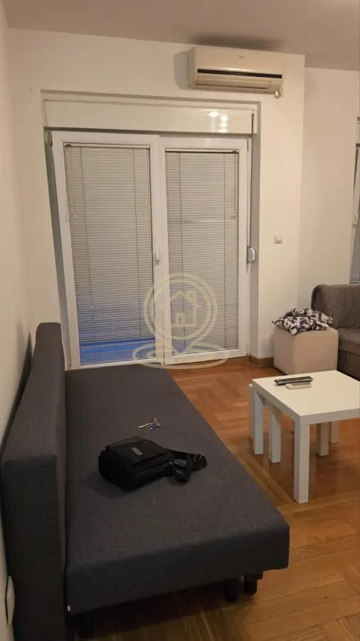 Dnevna soba sa garniturom, stočićem i klima uređajem.