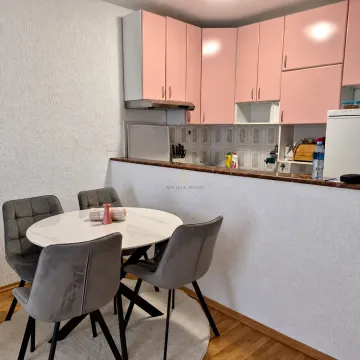 Kuhinja sa roze elementima i trpezarijskim stolom sa četiri stolice. - image 5