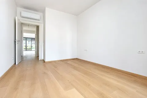 Prazna soba sa bijelim zidovima i drvenim podom. - image 12