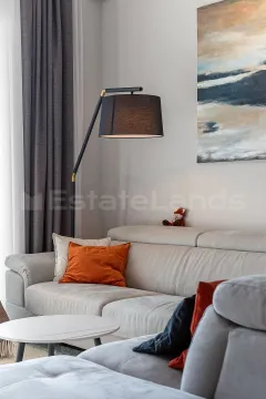 Moderan dnevni boravak sa garniturom, podnom lampom i umjetničkom slikom na zidu. - image 2