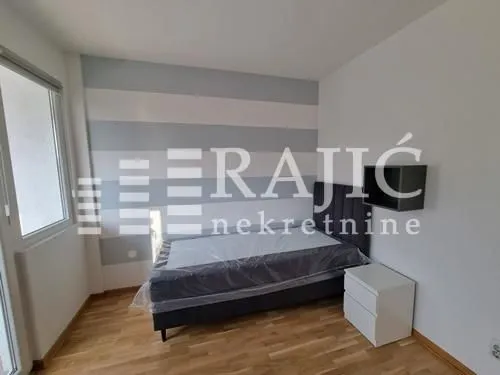 Furnished bedroom with a bed and a nightstand.