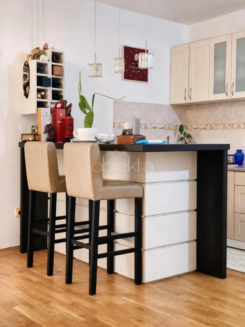 Kitchen with a bar counter and bar stools.