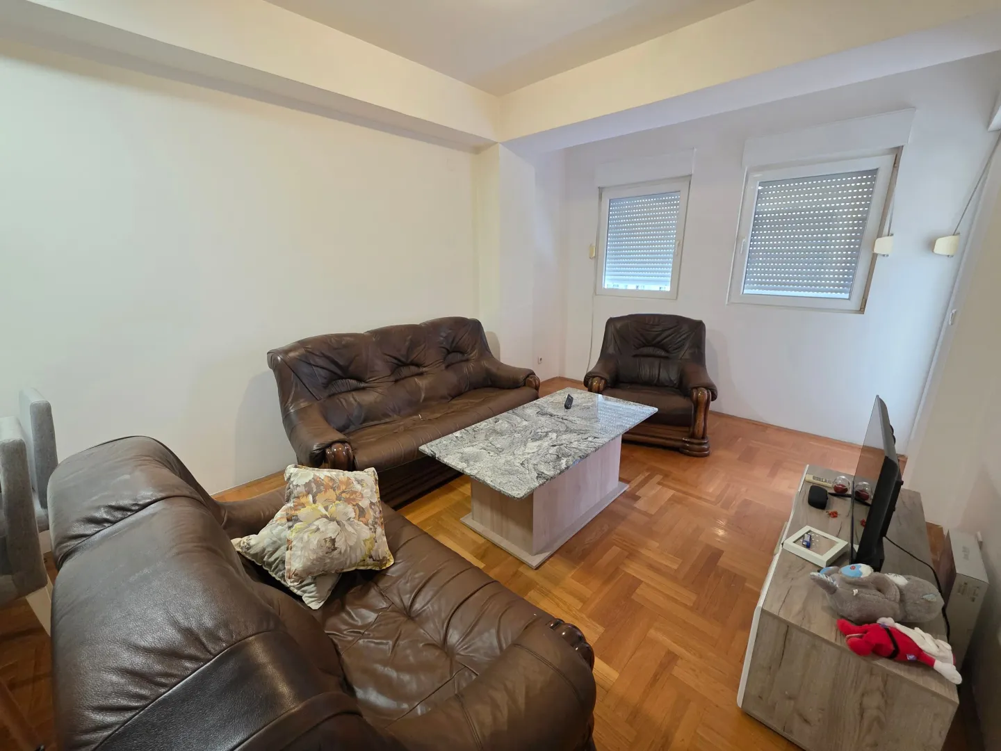 Living room with a seating set and parquet flooring.