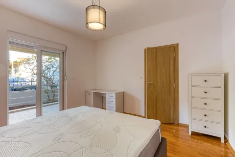 Bright bedroom with a bed, white dresser, and access to the terrace. - image 8