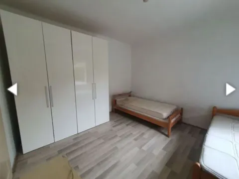 Bedroom with a large white wardrobe and wooden beds. - image 6