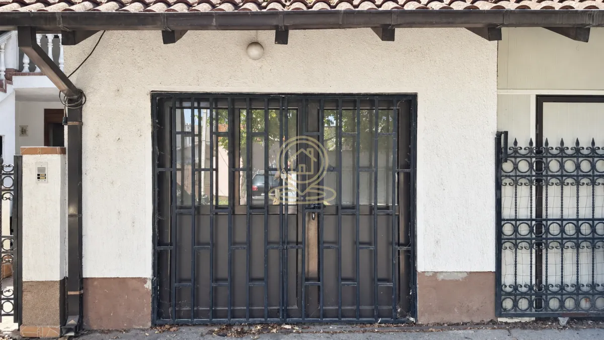 View of the entrance with metal doors and security bars on the house facade.