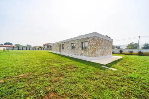 Single-story stone-clad house with a large grassy yard. - image 7