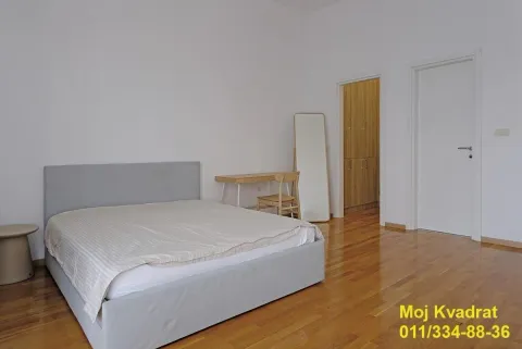 Spavaća soba sa bračnim krevetom, radnim stolom i drvenim podom. - image 7