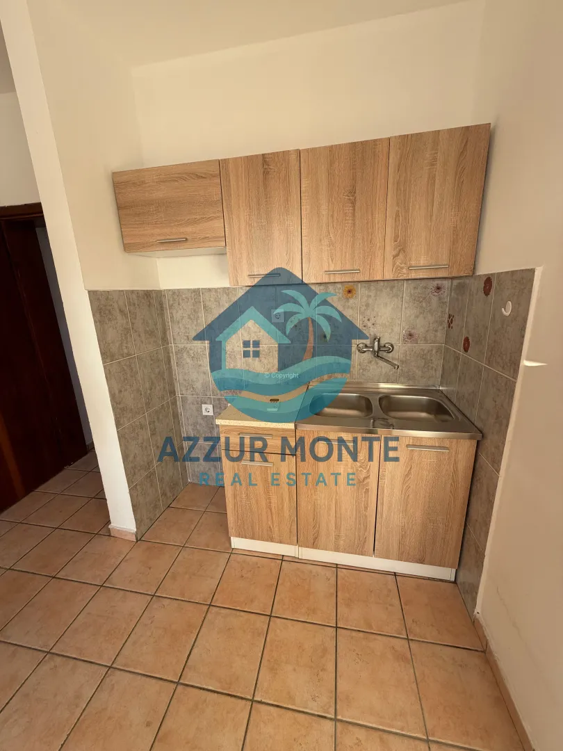 Smaller kitchen with wooden cabinets and a sink.