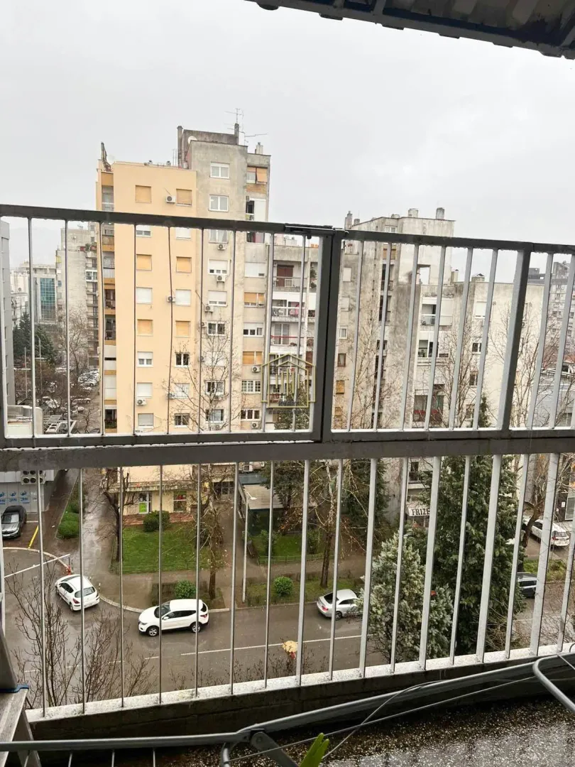 Pogled sa balkona na okolne stambene zgrade i ulicu.