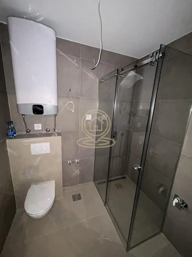 Kupatilo opremljeno tuš kabinom, WC šoljom i bojlerom.