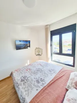 Spavaća soba sa bračnim krevetom, televizorom na zidu i prozorom. - image 7
