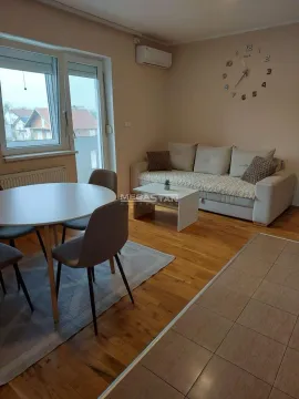 Dnevna soba sa garniturom, trpezarijskim stolom i velikim zidnim satom. - image 2
