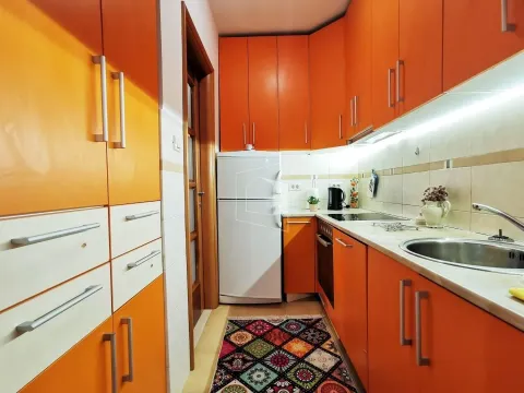 Bright kitchen featuring orange cabinetry and white appliances. - image 8
