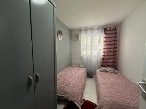 Bedroom with two single beds and a wardrobe. - image 12