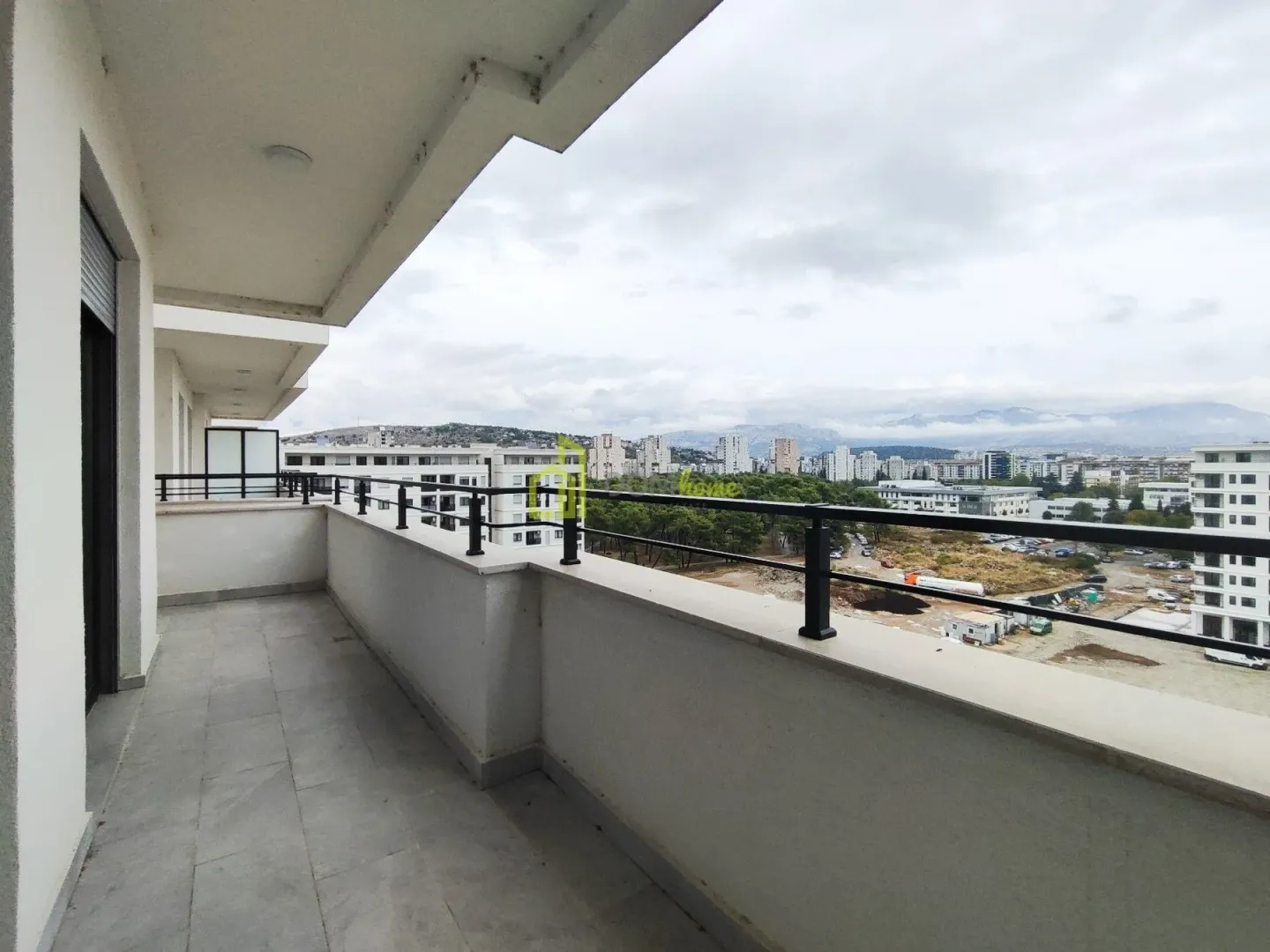 Spacious covered balcony with a view of the city and surroundings.