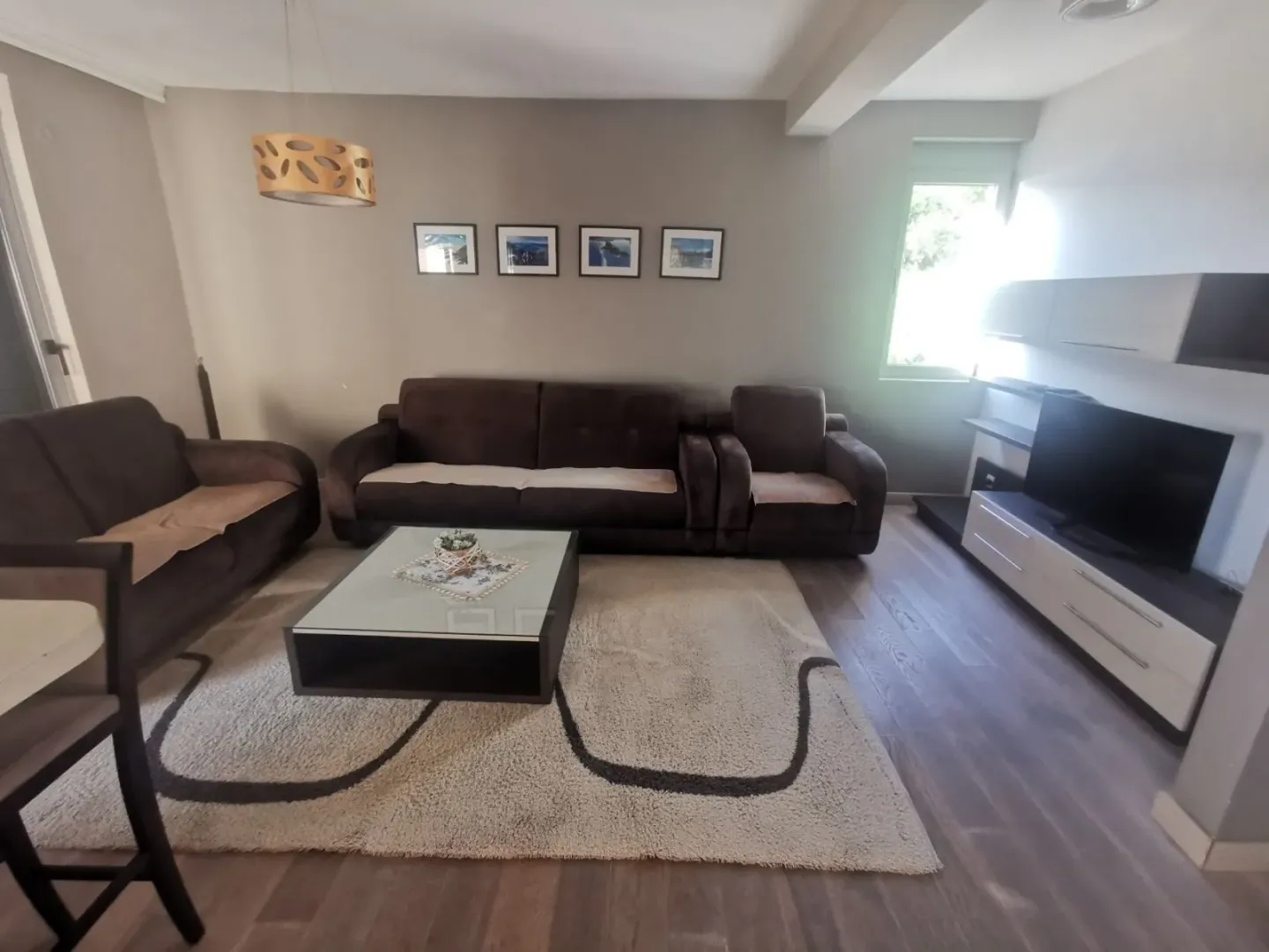 Furnished living room with a seating set and a TV.