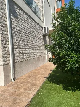 Eksterijer zgrade sa popločanim prolazom i zelenom površinom. - image 9