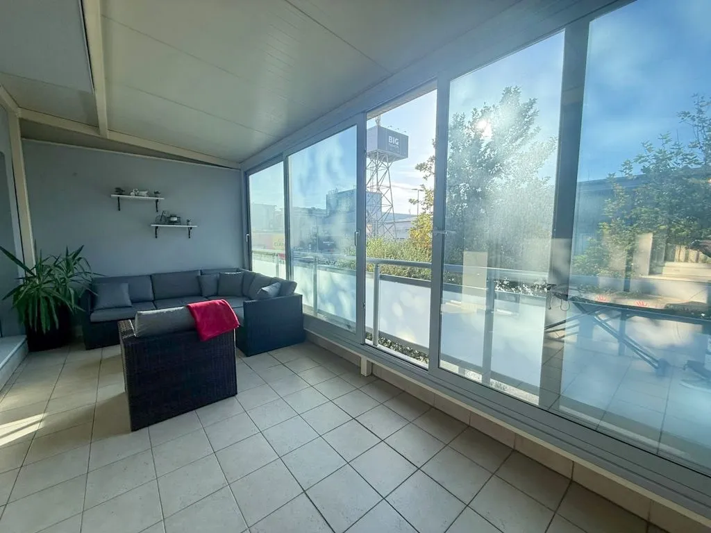 Enclosed terrace with seating furniture and a view of the surroundings.