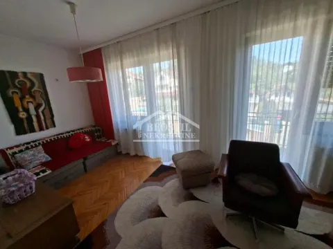Dnevna soba sa garniturom, foteljom i velikim prozorima sa belim zavesama. - image 15