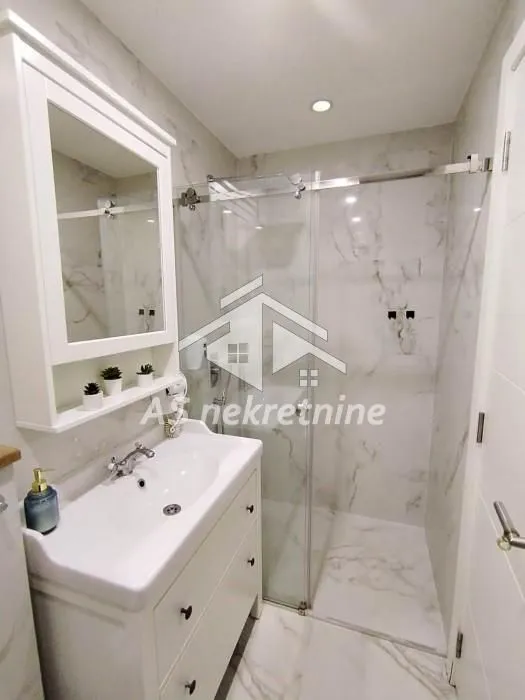 Modernly equipped bathroom with a washbasin and a shower cabin.