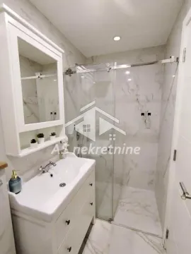 Modernly equipped bathroom with a washbasin and a shower cabin. - image 19