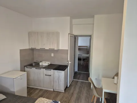 Small kitchen within the apartment with a dining table. - image 4