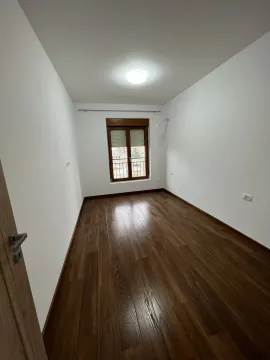 Prazna soba sa bijelim zidovima i tamnim podom. - image 6