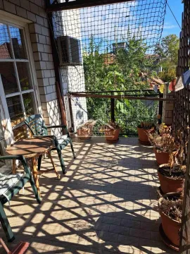Natkrivena terasa sa garniturom za sedenje i saksijama sa biljkama. - image 14
