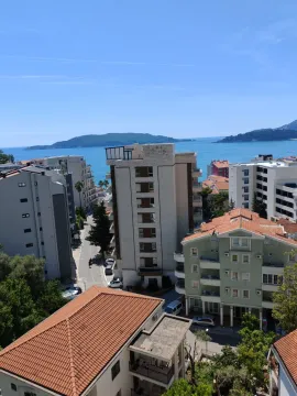 View of city buildings and the sea from the terrace. - image 9