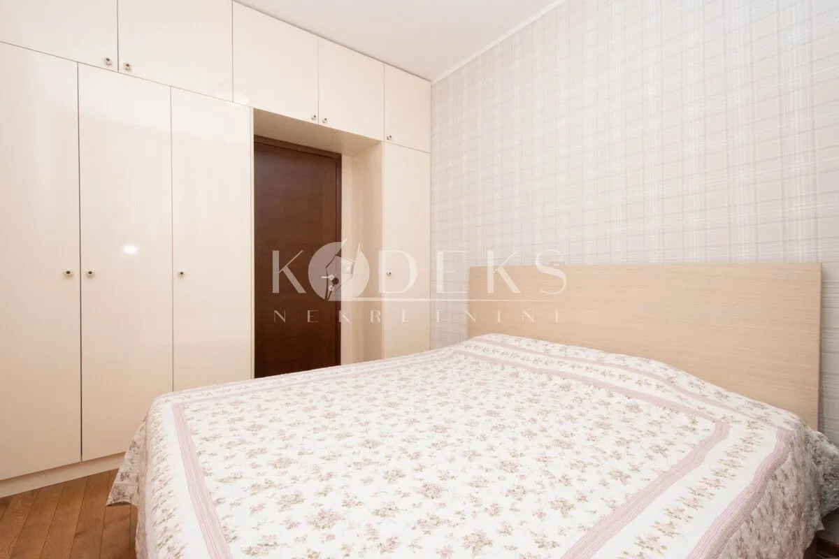 Bedroom with a double bed, fitted wardrobe, and a door.