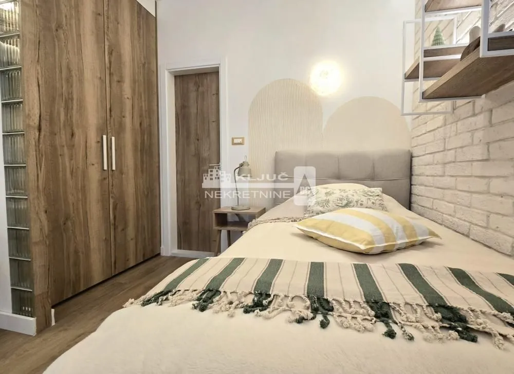 Furnished bedroom with a bed, wardrobe, and wall decor.