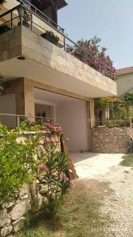 View of the exterior of the house with a terrace and landscaped yard.