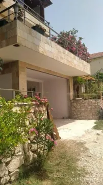 View of the exterior of the house with a terrace and landscaped yard. - image 6